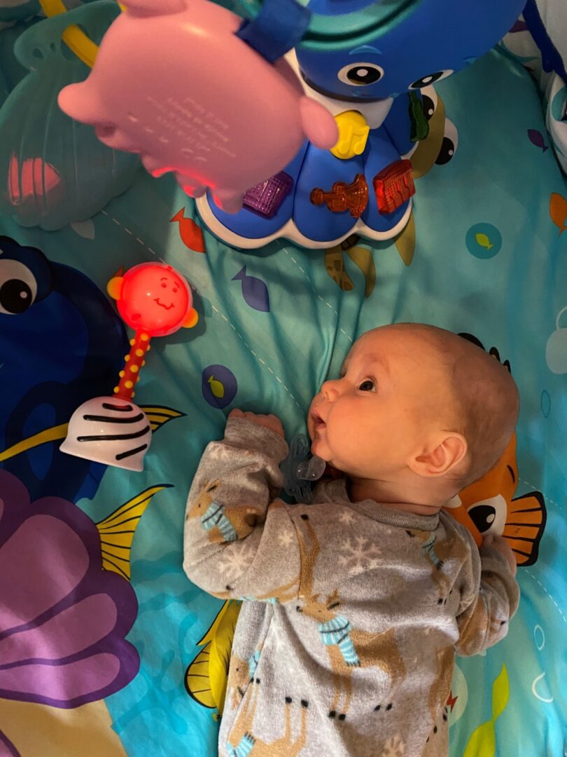 A toddler lying on an ocean-themed crib