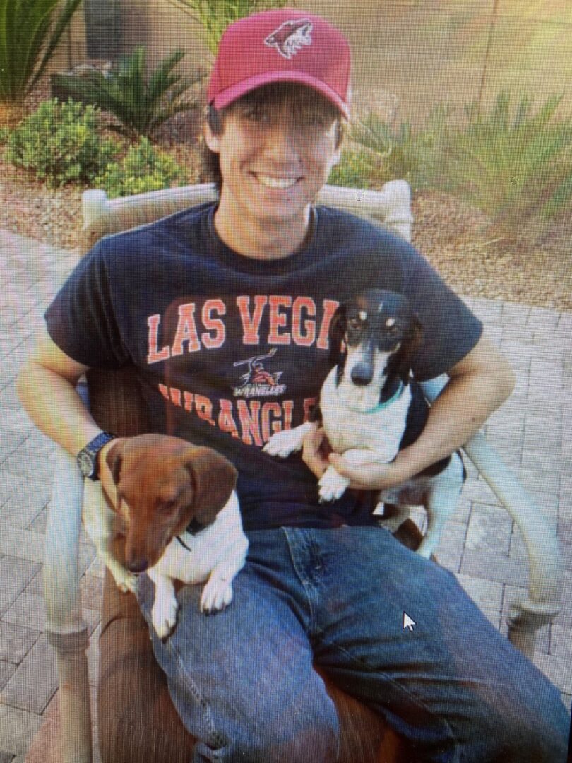 A man holding two adorable dogs