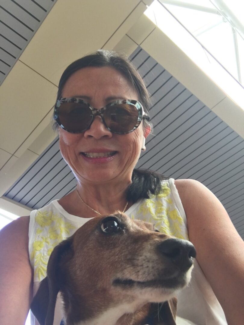 A woman wearing sunglasses with her dog